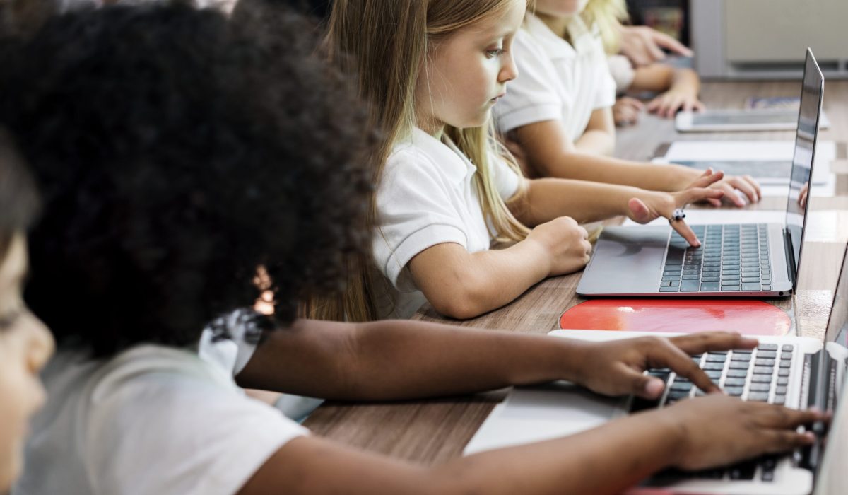 Enfants travaillant sur des ordinateurs dans une école primaire