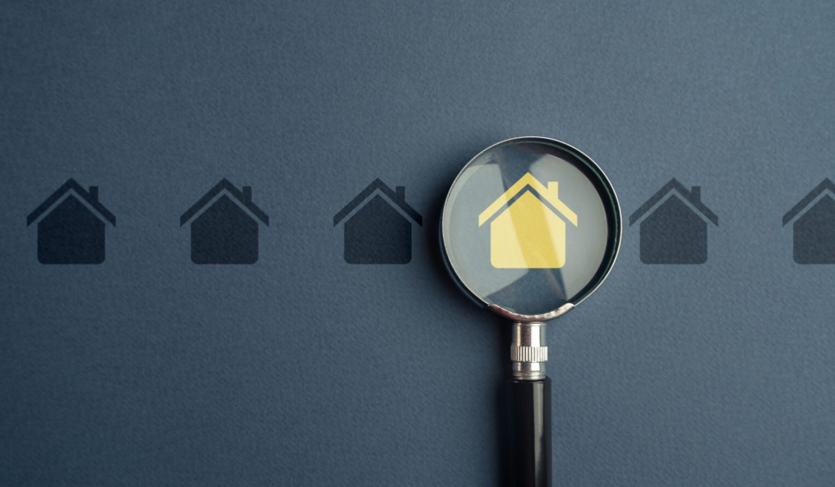 Une loupe agrandie sur une icône de maison jaune, parmi une rangée d'icônes de maisons grises en arrière-plan
